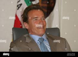 California Gov. Arnold Schwarzenegger, right, looks at Fresno Mayor, Alan  Autry, left, while taking calls