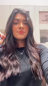 Adjusting Hair in a Bright Home Setting