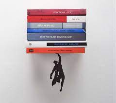 supershelf a book shelf that makes it look like superman is holding up your books floating bookshelves shelves under tv