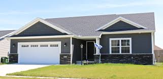 Grey roof shingle with blue sky background, house roof near sea in morning time. Dark Siding Combinations Carlson Exteriors Inc