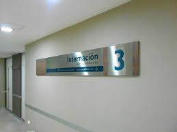 El sanatorio cuenta también con una sala equipada con un equipo de radiología, que permite realizar estudios con rapidez y de alta calidad diagnóstica. En Madera Y Acero Inoxidable La Calida Senalizacion Del Sanatorio Guemes Ayelen Industria Publicitaria