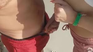 elle touche sa bite sur la plage publique