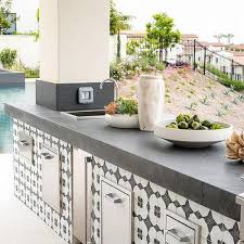 Nothing says summer quite like grilling outdoors, and if you're a serious fan of throwing some steaks on the grill whenever the weather permits, having a dedicated area in your yard is a great idea. White And Blue Outdoor Kitchen Tiles Design Ideas