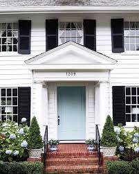 The front door is painted neon blue and beige as well. Blue And White Monday Curb Appeal White Exterior Houses House Exterior White House Black Shutters