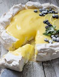 A Delicious Light And Fresh Dessert With A Meringue Base And A Light Lemon Curd Topping Garnished With Fresh Lemon Lemon Recipes Pavlova Lemon Curd Pavlova