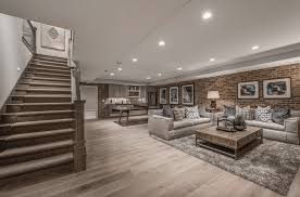 A Finished Basement With A Rustic Straight Staircase And Hardwood Flooring The Brick Wall In 2020 Basement Living Rooms Finished Basement Designs Basement Remodeling