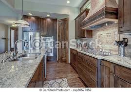 There are many options to choose from to fit your tastes as well. Luxury Dark Wood Rich Kitchen Interior With Copper Stove Hood And Grey Natural Stone Backsplash Canstock
