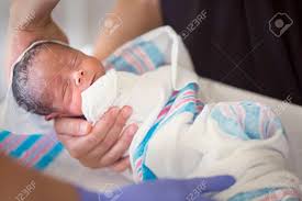 Here the baby is loosely swaddled in a bla. Newborn Infant Baby Getting His First Bath In The Hospital Cute Little Boy Is Bundled Up And Receiving A Sponge Bath By A Nurse In His Hospital Room Stock Photo Picture And