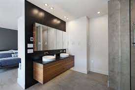 Pour Cette Premiere Salle De Bain Le Placage De Noyer Combine Au Dosseret De Ceramique Noir Et Au Comptoir Bathroom Lighted Bathroom Mirror Bathroom Lighting