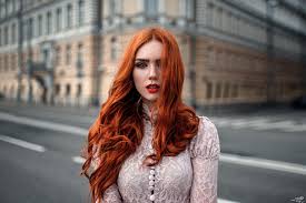 Her head raises a bit. Wallpaper Women Outdoors Redhead Model Street Long Hair Blue Eyes Glasses Urban Building Open Mouth Looking At Viewer Wavy Hair Red Lipstick Georgy Chernyadyev Fashion White Clothing Windy Hair In Face