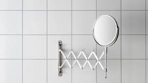 Lovely guest bathroom features frameless mirror over white washstand composed of ikea akurum cabinets topped with bianco carrara marble and oval sink accented with gooseneck faucet. Mirrors Ikea