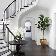 Curved Staircase Wall With Black Round Table Like This Look Need Help With A Renovation Www Cooperhomesinc Com Foyer Design Staircase Decor Staircase Design