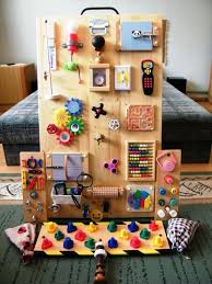 Fabriquer Un Panneau Sensoriel Montessori Pour Occuper Les Petits Enfants Panneaux Sensoriels Tableau D Activite Mur Sensoriel