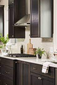 Dark woodwork and cabinetry and paired with rich, dark quartz countertops on the island, perimeter counters, and seating area. Portfolio Carla Bast Design Quartz Countertops Dark Cabinets Stained Kitchen Cabinets Dark Kitchen Cabinets