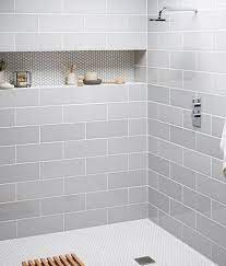 A traditional master bathroom has a modern feel with clean white subway tiles and herringbone mosaic. These 20 Tile Shower Ideas Will Have You Planning Your Bathroom Redo