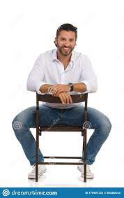 Green screen (also blue screen) is the use of a single color as a backdrop in filming to make it simpler and easier to add backgrounds, characters or other i. Handsome Smiling Man Is Sitting Astride A Chair Front View Stock Photo Image Of Isolated Sitting 170923722