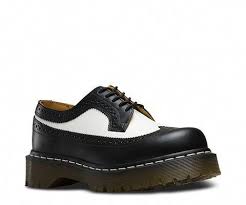 Black And White Wingtip Doc Martens First Made In The Mid 60s The Unisex 3989 Brogue Shoe Features A Unique Combo Of Black And White Wingtip Style With Thick Extra Chun White Oxford Shoes Doc Martens Boots Bootie Boots