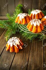 The intricate detail complete with ornaments and toy train will charm children and adults alike. Small Christmas Bundt Cakes With Sugar Glaze On A Rustic Wooden Table With Christmas Tree On The Background Copy Space Vertical Image Stock Photo Picture And Royalty Free Image Image 138418230
