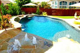 another stunning example of a freeform pool with tequila table and splash pad by dallas fort worth swimming pool build splash pool pool swimming pool builder