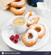 Donuts and coffee on morning breakfast table Stock Photo ...