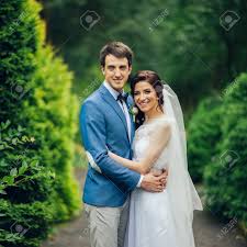 Photo by heather hawkins, floral design by bows and arrows with moss floral via hey wedding lady. Pretty Wedding Couple Poses In A Green Spring Garden Stock Photo Picture And Royalty Free Image Image 93283833