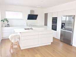 kuche ganz in weiss mit keramikarbeitsplatte spulinsel und grossen side by side kuhlschrank kuche holzboden moderne kuche wohnung kuche