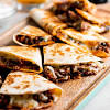 Classic tex mex fajitas recipe, made with strips of skirt steak, onions and bell peppers, and served sizzling hot with fresh tortillas, guacamole, sour cream, and salsa. 1