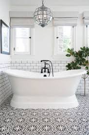 Stand Alone Bath Tub With Subway Tiled Walls And Black And White Patterned Tile Flooring Lifestyle Serene Bathroom Black Bathroom Bathroom Makeover