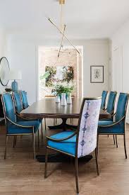 A Modern Brass Chandelier Lights A Live Edge Dining Table Surrounded By Sapphire Velvet Dining Room Chairs Velvet Dining Chairs Blue Velvet Dining Room Chairs