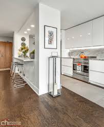 In a modern bachelor pad, the kitchen island is stainless steel and walnut, the sink is by julien, the fittings are by dornbracht, and the stool is by bddw; Chicago Modern Condo Living Chi Renovation Design