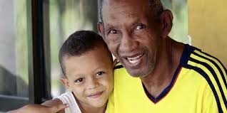 Download Antonio Cervantes With His Grandson Smiling Wallpaper