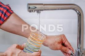 Plop Plop Fizz Fizz Oh What A Relief It Is Photograph Man Pouring Glass Of Water From Tap With Clean Filter In Kitchen Close Up 94441317 Tap Cleaner Cleaning Filters