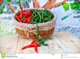 Red And Green Hot Chili Peppers In A Basket On A Wooden