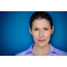 Zwischen Blau und Blick: Schauspielerin Lena Vogt vor einer klaren  Farbkulisse. Ihre Augen greifen das Blau der Wand auf