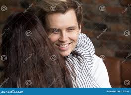 Giovane Uomo Sleale Del Bugiardo Che Sorride Felicemente Mentre Donna Che  Lo Abbraccia Fotografia Stock