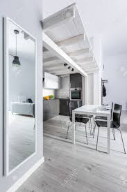 Just make sure to hang them in the same manner as artwork, where proportion is taken. Kitchen And Dining Area With Big Mirror On Wall Reflecting Living Room Stock Photo Picture And Royalty Free Image Image 92527359