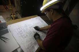 Electrician Reviewing Blueprints By The Light Of The Halo Light Blueprints Electrician Light