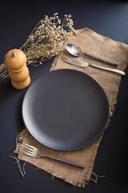 The fruit fork and fruit spoon are positioned horizontally above the plate, with the handle of the fork towards. Top View Of Empty Table Setting Of Black Plate Fork Knife Spoon And Pepper Grinder On Burlap On A Black Table 2037858 Stock Photo At Vecteezy