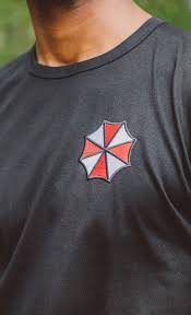 Umbrella Corporation Insert Coin Clothing This black tee from resident evil 2 features the umbrella corporation logo on the left chest and on the back with umbrella text design. umbrella corporation insert coin clothing