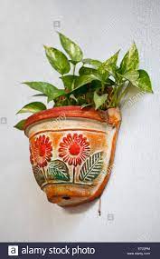 Grüne wände sind einfach schön, deshalb bastle ich gerne gefäße für meine pflanzen als diy variante mit konservendose: Ton Blumentopf Auf Einer Weissen Wand Hangen Stockfotografie Alamy