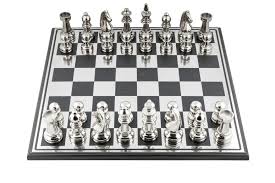 An army of grey and black pieces face off against an ivory army, standing atop a checkered board of grey and ivory. Nickel Plated Chess Set Marina Home Interiors Marina Home Interiors