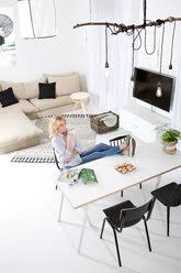 Beautiful woman bare feet up on the table in warm classy interior with large glass window and luxury view of the snowy landscape. Woman Sitting With Feet Up On The Table In Her Living Room Watching Magazine Stockphoto