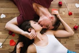 Couple lying and kissing on floor with ...
