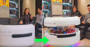 Here is a smart coffee table that also keeps your drinks cold, plays your music, and charges your smart devices. The Coosno Is A Smart Coffee Table With A Built In Fridge Stereo And Draw For Storage