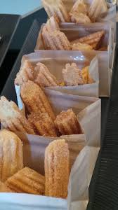 Dessert Detail Of Churros Neatly Packaged In Personal Sized Brown Bags For Authenticity