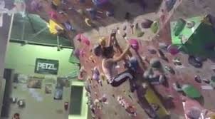 Construction worker in yellow helmet and orange reflective waistcoat climbing a ladder. Toucher Videos Facebook