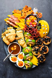 A square white plate with chicken and roasted vegetables in the foreground, with a sheet pan of chicken in the background. Easy Halloween Food Ideas Halloween Snacks Foxes Love Lemons