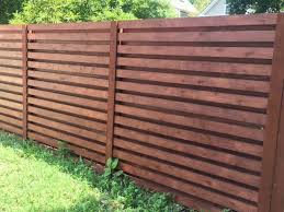 A scalloped partial privacy fence installed on a slope by the fence authority. Wood Fence Installation Chicago First Fence Company