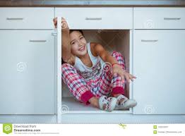 child hiding in the kitchen cupboard