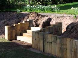 Using Vertical Sleepers As A Retaining Wall Sleeper Retaining Wall Sloped Backyard Landscaping Sloped Garden